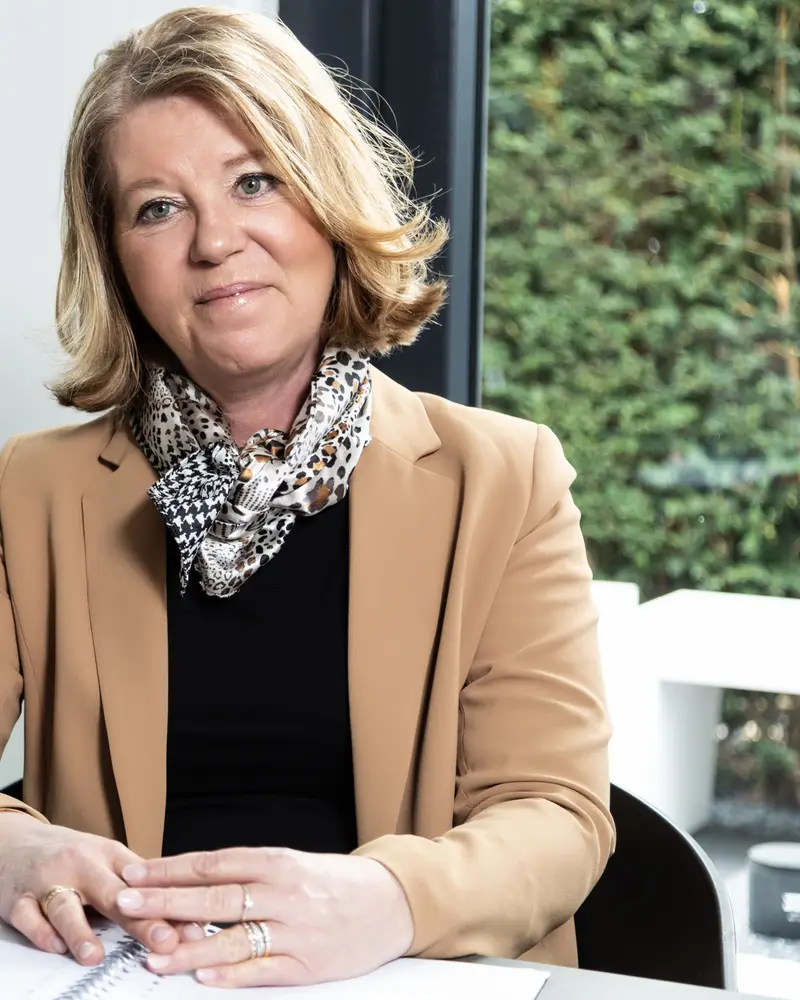 Claudia Blom luistert aan tafel in haar praktijk